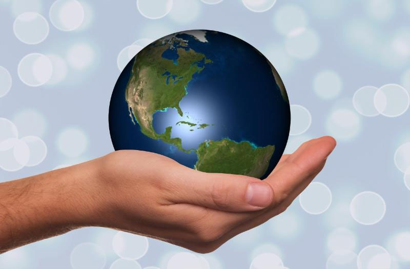 Photo of a hand holding a globe depicting sustainability