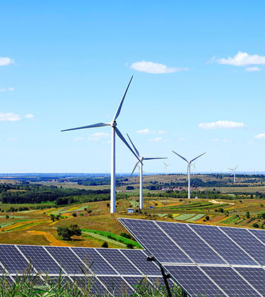 Photo with clear blue sky with wind turbines and solar panels across several farm fields