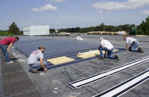 Photo of students installing roof top solar panels