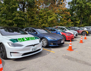 REVUP EV car parked alongside other cars.